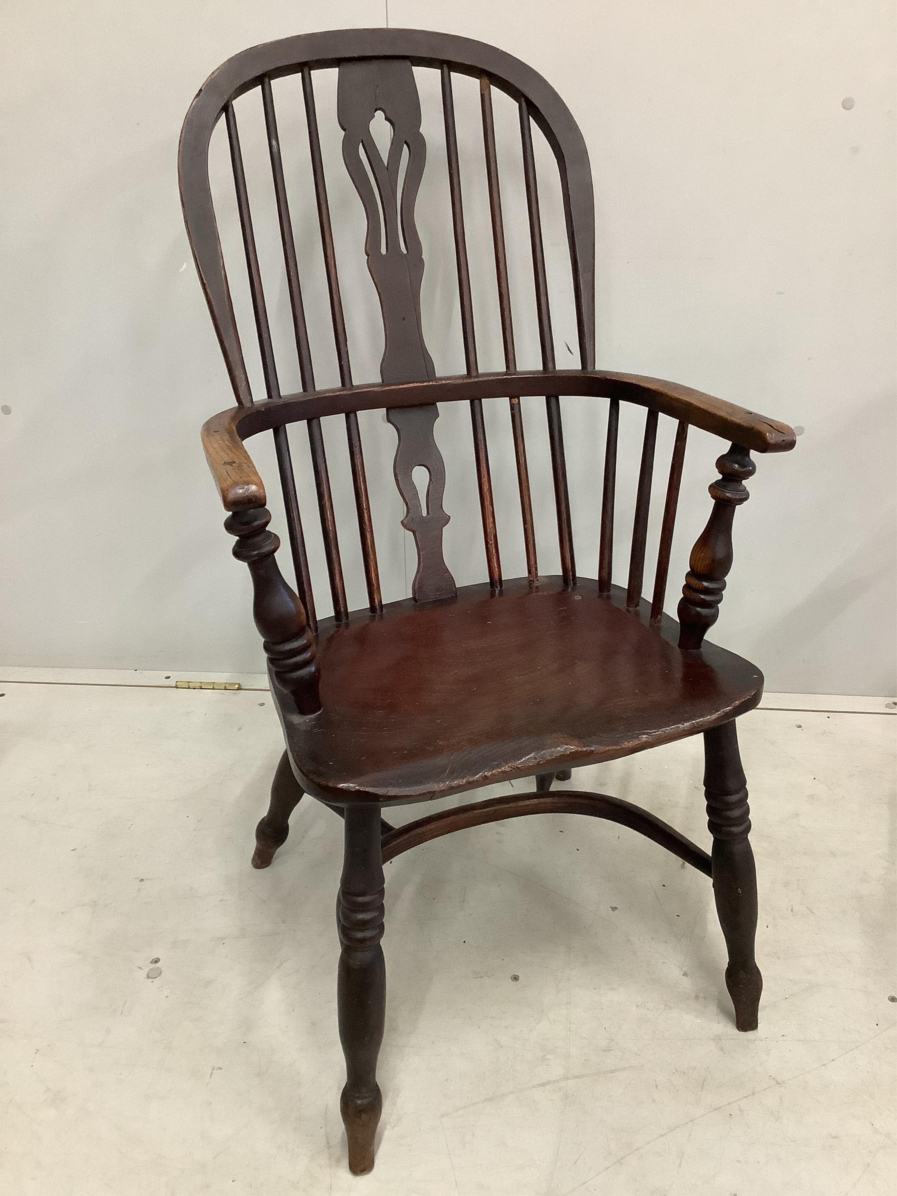 A 19th century ash and elm Windsor comb back armchair with crinoline stretcher, width 54cm, height 100cm together with a later Windsor elbow chair. Condition - poor to fair